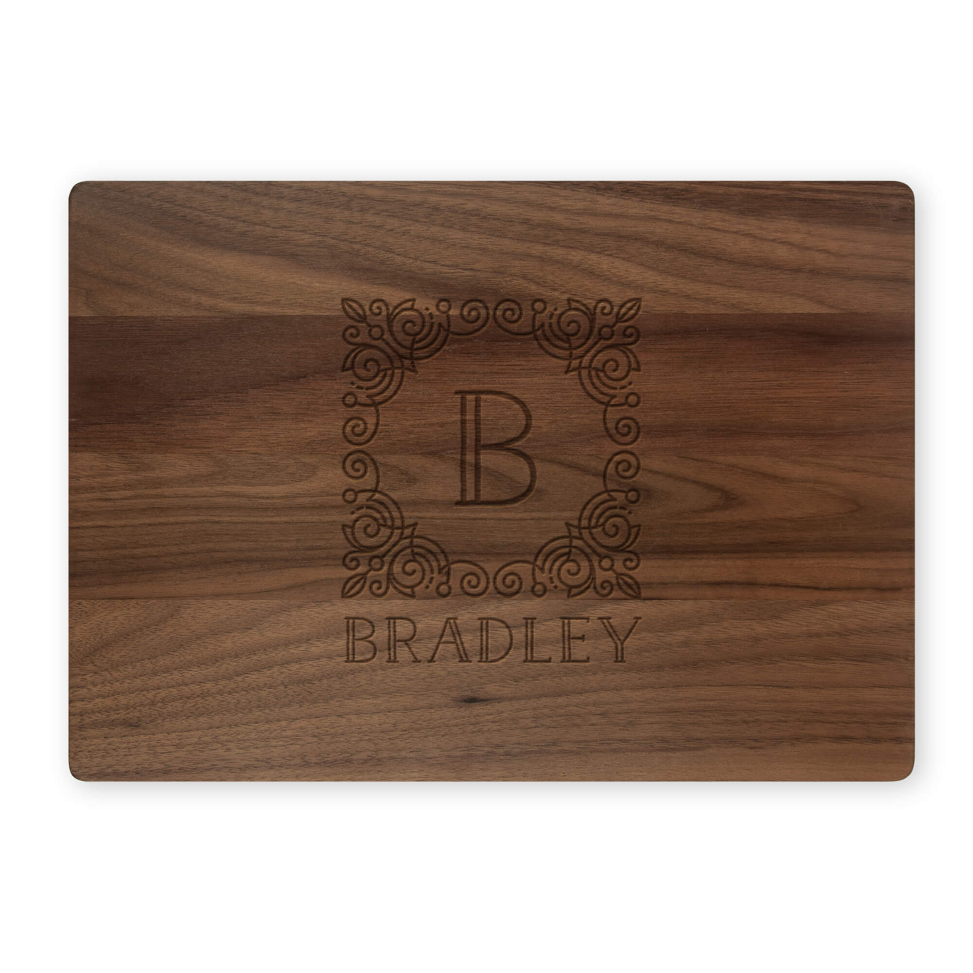 Walnut cutting board engraved with ornate B monogram and Bradley name, isolated on white background