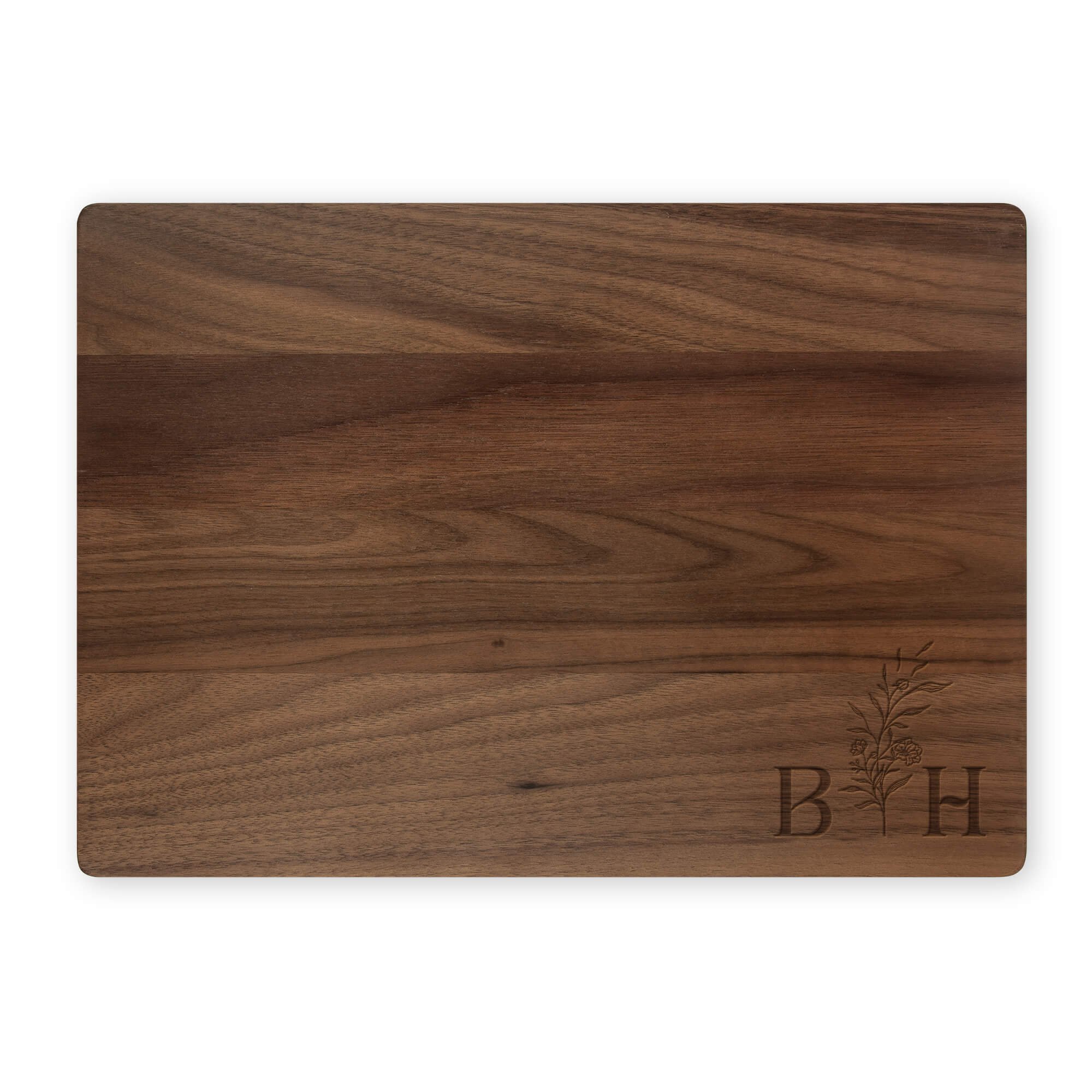 Engraved walnut cutting board featuring floral initials “B” and “H.” Custom monogram cutting board for kitchen décor, weddings, or personalized home gifts.