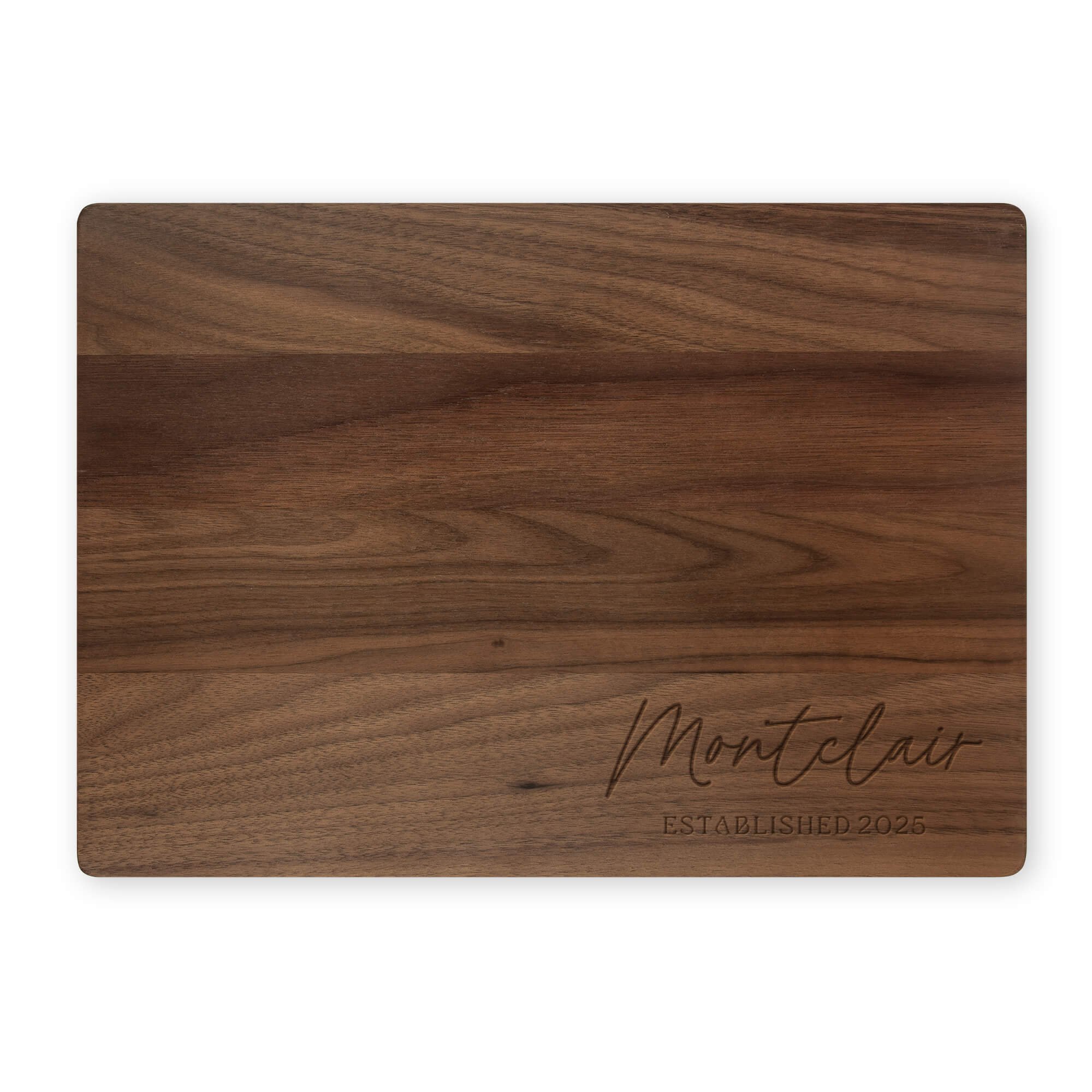 Personalized walnut cutting board engraved with “Montclair Established 2025.” Custom dark wood cutting board or family name kitchen gift.